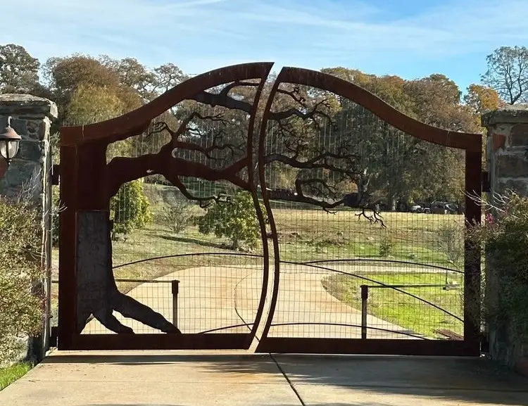 Custom rustic driveway gate with tree silhouette design cut into metal panels at a residential property in Folsom.